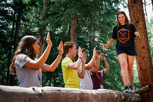 student walking across log